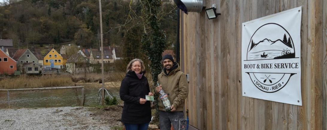 zwei Personen halten eine Flasche mit Pfennigstücken