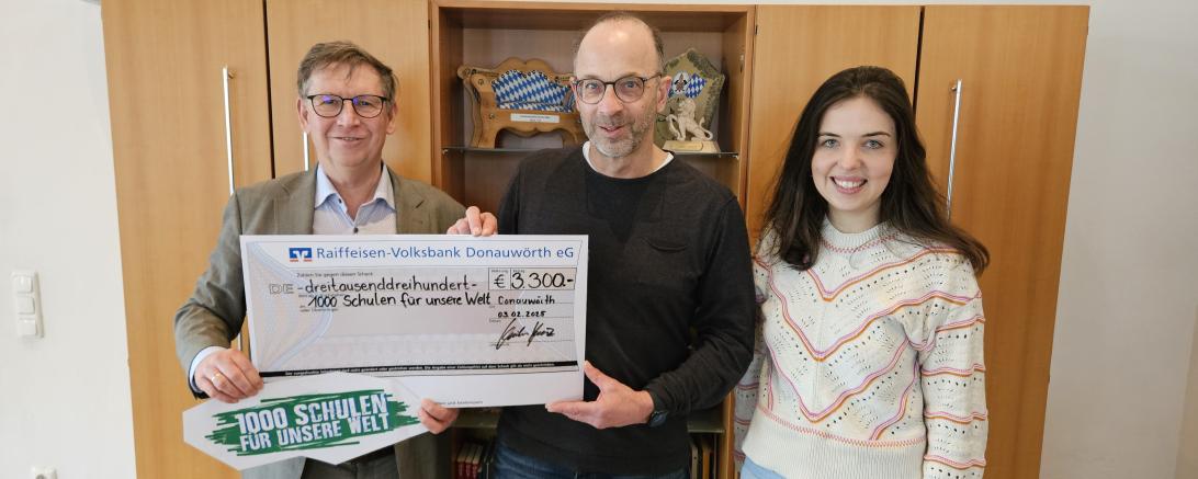 drei menschen halten einen spendenschein