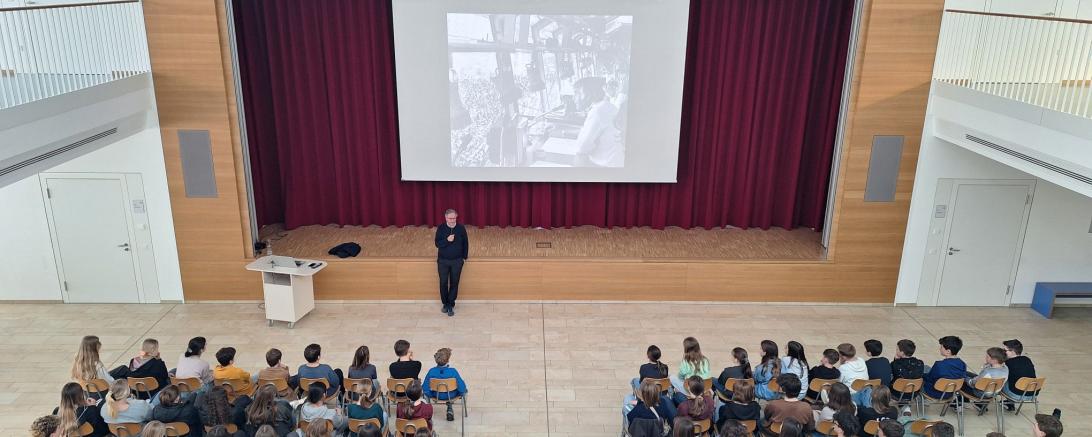 Zu sehen ist Roman Deininger Deininger vor dem Foto von Joachim "Blacky" Fuchsberger, dem Stadionsprecher der Schlussfeier der Olympischen Spiele 1972.