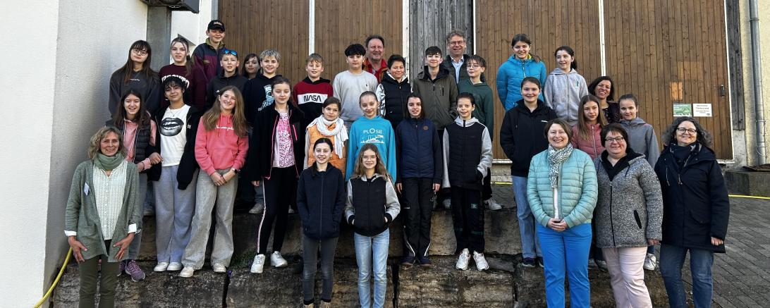 Auf dem Bauernhof von Familie Leinfelder lernten die Schülerinnen und Schüler der örtlichen Realschule im Rahmen des Programms „Erlebnis.Bauernhof“ viel Wissenswertes rund um das Thema Milch, Kuh und Getreide. Begleitet wurden sie dabei von ihrem Lehrer Gerhard Reissig (hinten 1. von li.), Auf dem Foto zudem: Behördenleiter Dr. Reinhard Bader (hinten 2. von li.), Edith Auchter (AELF, vordere Reihe, 1. v.l.n.r.), Vizelandrätin Claudia Marb (vordere Reihe, 2. v.l.n.r.), Stellvertretende Kreisbäuerin Susanne L