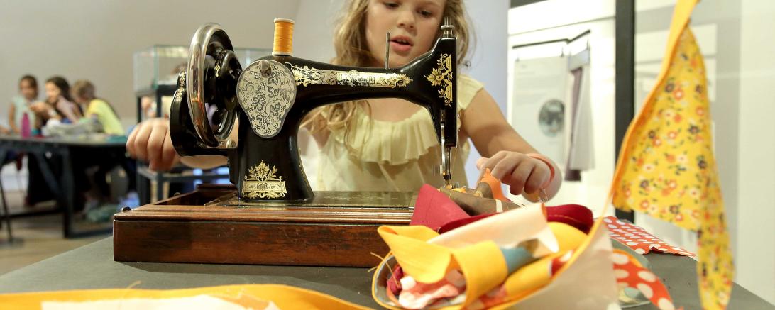 Ein Kind an einer Nähmaschine