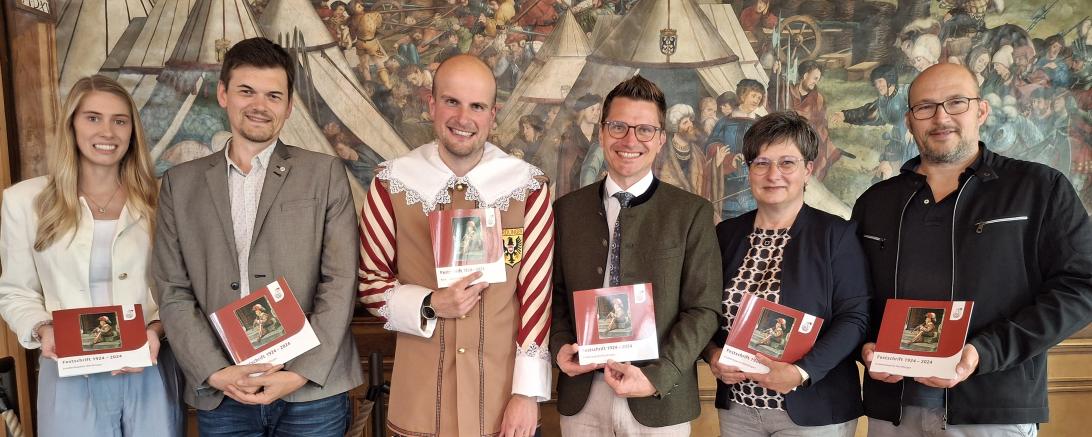 (v.l.) Hauptverwaltungsleiterin Helena Ott, Stadtarchivar Dr. Johannes Moosdiele-Hitzler, Stadtkapellmeister Oliver Körner, Oberbürgermeister David Wittner, Birgit Kapeller (Hauptverwaltung) sowie Thomas Volk (Druckerei Steinmeier) präsentieren die Festschrift zum 100-jährigen Jubiläum der Knabenkapelle Nördlingen.