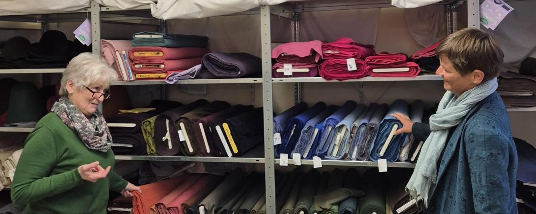 Leiterin der Nähstube, Brigitte Wirth (links), und Nähdame Susanne Schaffer (rechts) vor den Stoffen für histori-sche Gewänder im Stofflager in der ehemaligen Jugendherberge an der Kaiserwiese.