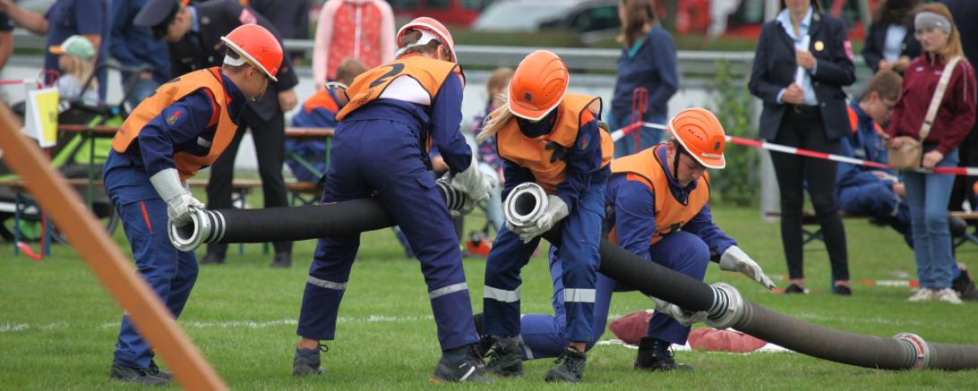 Jugendliche beim Absolvieren des Hindernisparcours, bei dem verschiedene feuerwehrtechnische Aufgaben bewältigt werden mussten.