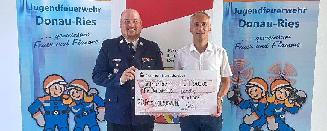 Christian Weiland (r.), Geschäftsstellenleiter der Sparkasse in Wemding, übergibt die Spende an Kreisjugendfeuerwehrwart Markus Meyr.