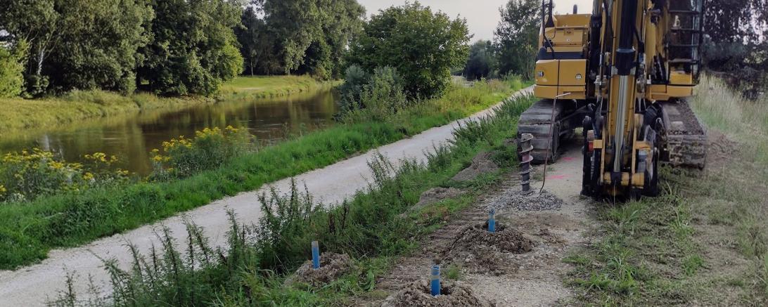 Das Foto zeigt die Kampfmittelerkundung auf dem Deich mit den Bohrlöchern im Vordergrund.