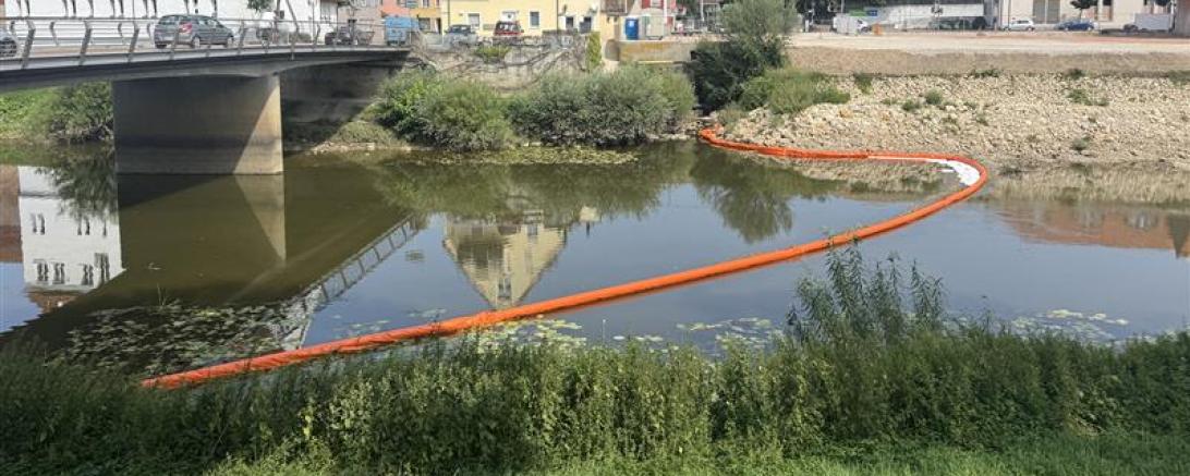 Die Feuerwehr will durch Barrikaden ein Eindringen des Ölteppichs in die Wörnitz verhindern.