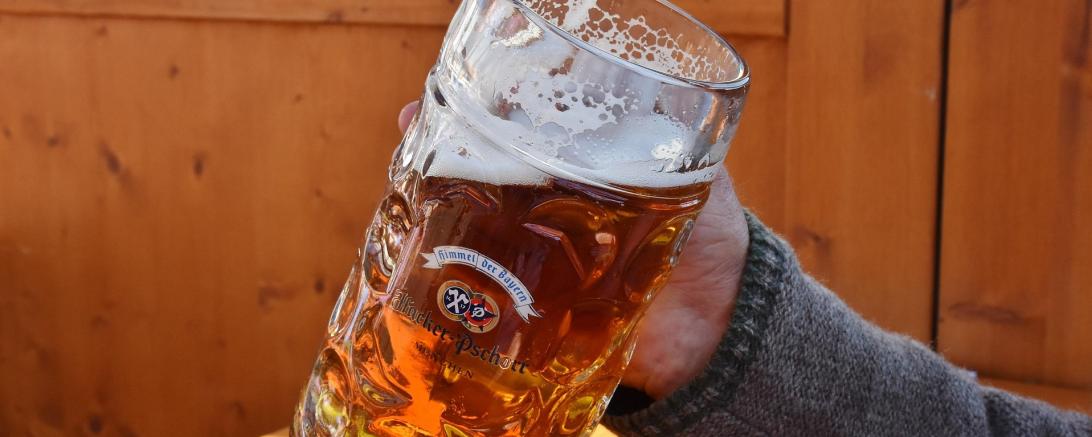 Das Bild zeigt einen Arm, der ein Maß Bier hält.
