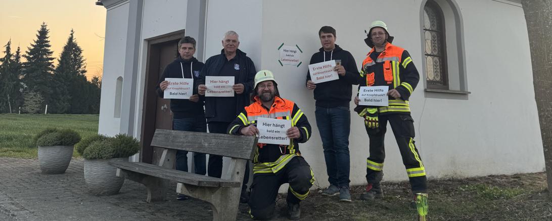 Angehörige der Freiwilligen Feuerwehr Zusum-Rettingen von der Kapelle in Rettingen, wo mit finanzieller Unterstützung von Oettinger ein Defibrillator angebracht werden soll.