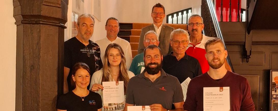 Die Preisträgerinnen und Preisträger der Team- und Einzelwertung bei der Preisverleihung im Rathaus: (1. Reihe v. l.): Christiane Emde (Fit for Life), Inka Moewes (Destilla), Michael Mittring (Baldinger Vereine), Jan Schmalfeld, (2. Reihe v. l.): Dieter Mittring (Baldinger Vereine), Klimaschutzmanager Holger Biller, Friedolin Imm, Jörg Stadali, (3. Reihe v. l.): Oberbürgermeister David Wittner, Thomas Mittring (Baldinger Vereine).