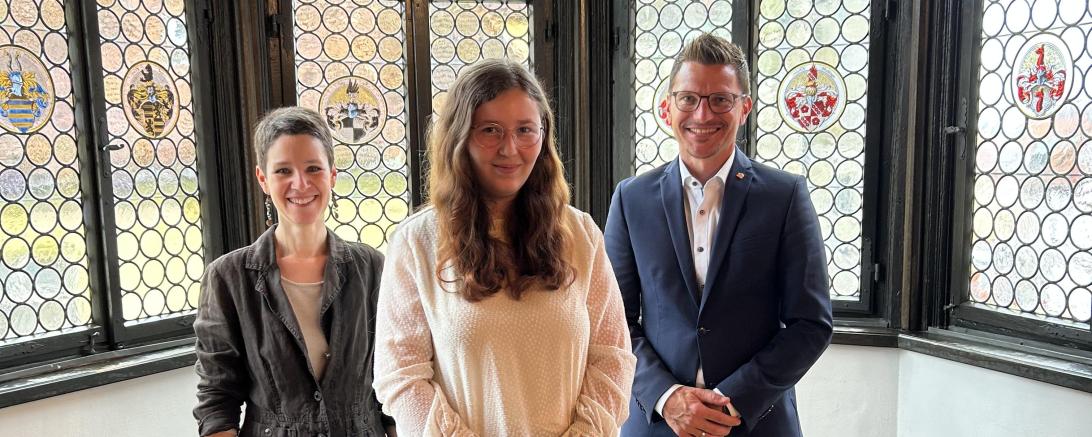 Feierlicher Moment: (v. l.) Bibliotheksleiterin Kathrin Häffner, Absolventin Emilia Götz und Oberbürgermeister David Wittner bei der Übergabe des Abschlusszeugnisses.