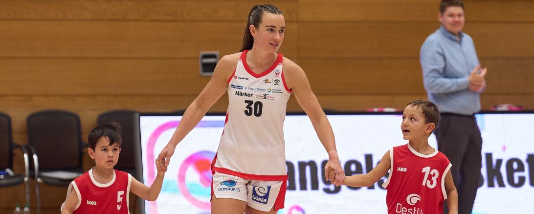Weniger freundlich flankiert, wie hier von den Einlaufkindern beim Heimspiel gegen Hannover, wird die aktuelle Topscorerin der Liga, Samantha Ashby, beim Auswärtsspiel in Saarlouis. Hier erwartet sie und ihr Team, die Eigner Angels aus Nördlingen knallharte Defense vom Pokalsieger und deutschen Vizemeister, den Saarlouis Royals. 