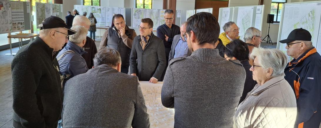 Oberbürgermeister David Wittner (Bildmitte) im Gespräch mit interessierten Bürgerinnen und Bürgern bei der Eröffnung der Ausstellung der Wettbewerbsarbeiten zum „Wohnpark Ost“.