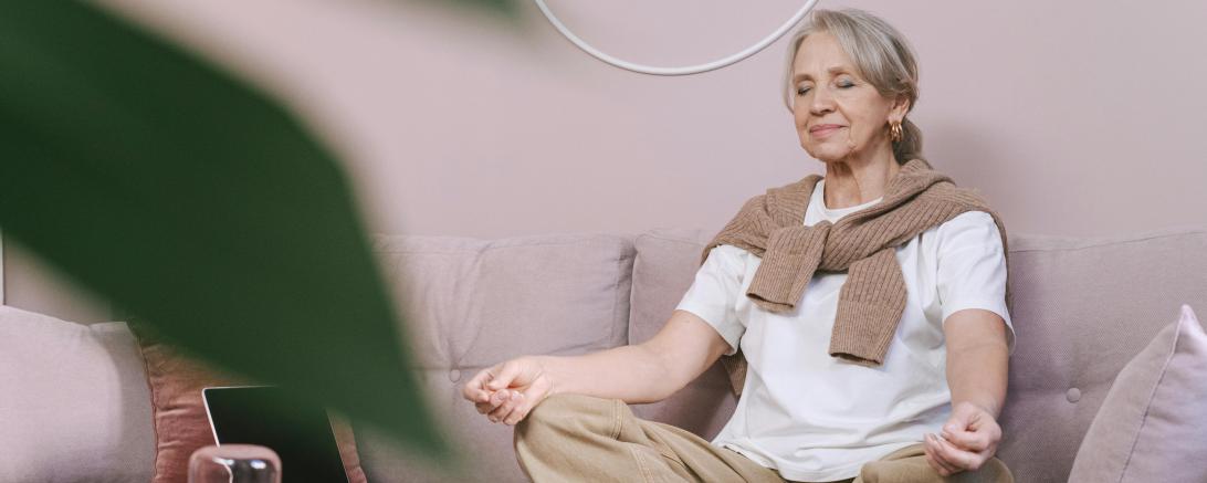 Frau meditiert auf dem Sofa