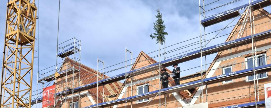Feierlicher Moment im Eger-Viertel: Beim Richtfest der neuen Kindertagesstätte freuen sich 3. Bürgermeisterin Gudrun Gebert-Löfflad, Sebastian Haag, Vertreterinnen und Vertreter der Katholischen Jugendfürsorge, der Stadtverwaltung und zahlreiche Handwerkerinnen und Handwerker über den zügigen Baufortschritt.