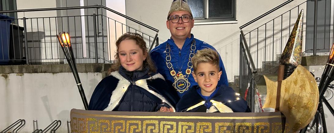 Das Kinderprinzenpaar Nele I. Hüterin des Olympischen Feuers (Wolff) und Noel I. von den Olympischen Kämpfern (Kampfinger) gemeinsam mit Präsident Johannes Schimmer. 