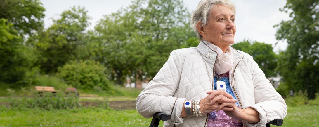 Das Bild zeigt ein Seniorin mit Notruf-Armband.