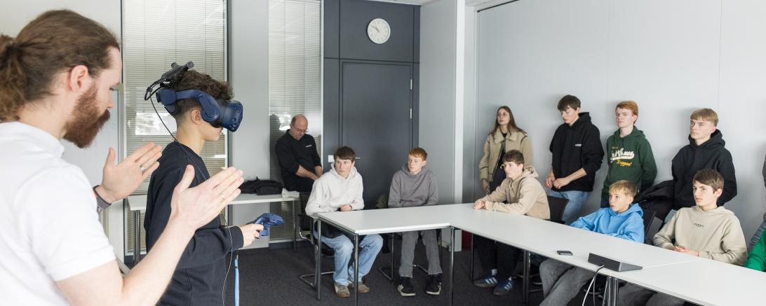 Die Schülerinnen und Schüler konnten unter Anleitung eines Mitarbeiters bei der Grenzebach Maschinenbau GmbH eine VR-Brille im unternehmerischen Kontext testen.