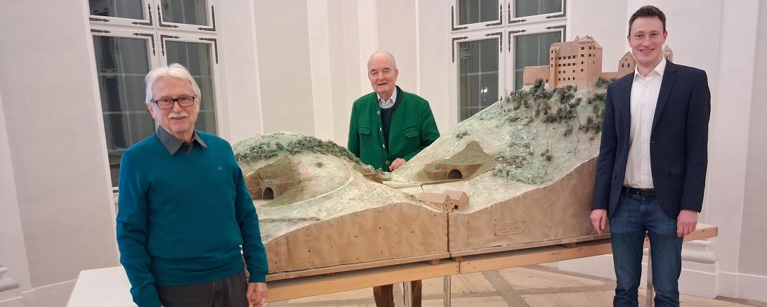 Auf dem begleitenden Bild sind Dieter Thiel, Marco Pulci und Seine Durchlaucht Fürst Moritz zu Oettingen-Wallerstein vor dem Modell von Burg- und Hölltunnel vor Schloss Harburg zu sehen.