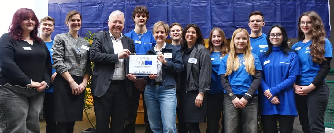 MdEP Markus Ferber, Schulleiterin Anja Heßlinger sowie Simone Götz (Mitte) und Barbara Heinrich (3. von links) freuen sich mit Schülern der AG EPAS über die Auszeichnung als Botschafterschule