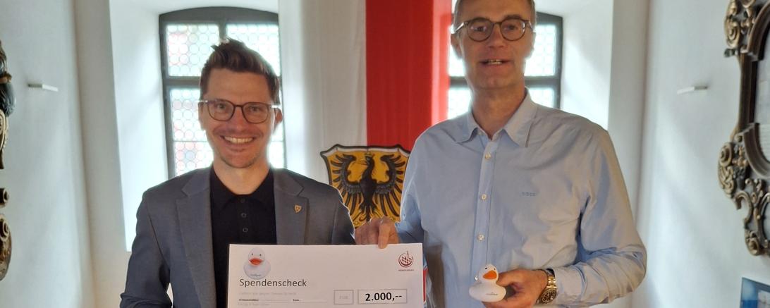 Spendenübergabe im Nördlinger Rathaus: Oberbürgermeister David Wittner überreicht die Spendensumme von 2.000 Euro aus Entenrennen und „Kraterbad-Enten“ an Martin Stumpf vom Verein „Vier Steine für Afrika e.V.“.