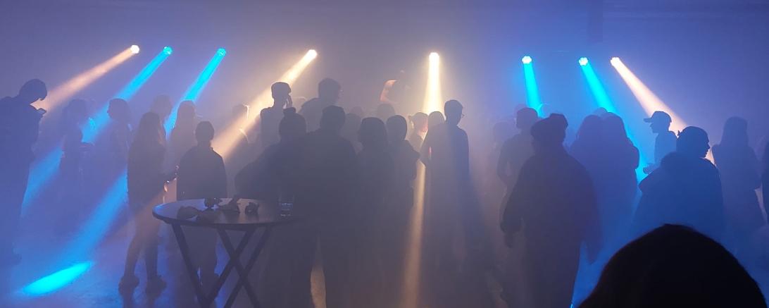 Zwischen Nebel, Beats und bunten Lichtstrahlen feiert die Menge ausgelassen auf der Tanzfläche.