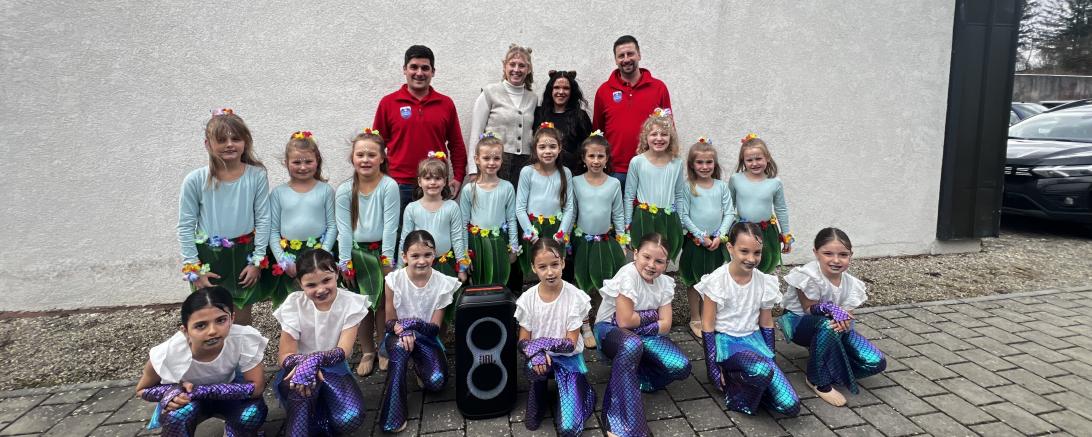 Auf dem Bild sind hinten v. l. n. r. Christian Baur (1. Vorstand der Rot-Weissen-Burgstädter e. V.),  Meike Jörg und Alina Schmidt (Trainerinnen der Just Dance Tanzgruppen) und Martin Müller (2.  Vorstand der Rot-Weissen-Burgstädter e. V.). In den vorderen beiden Reihen sind Tänzerinnen der  Just Dance Minis und Kids zu sehen