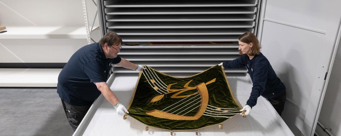 Eine Fahne wird in einem Spezialschrank eingelagert