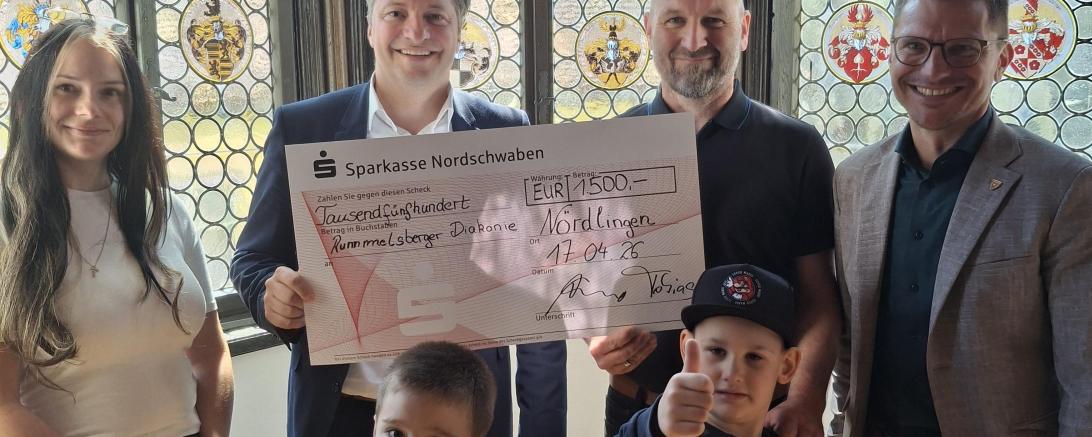 Spendenübergabe im Nördlinger Rathaus: Tobias Güntner (2. v. l.) und Oberbürgermeister David Wittner (1. v. r.) überreichen den symbolischen Scheck über 1.500 Euro an Wolfgang Salcher (2. v. r.), Nadja Goß (1. v. l.) sowie zwei Kinder aus der Einrichtung.