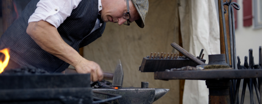Der Schmied formt glühendes Metall in Kunst und Alltagsgegenstände