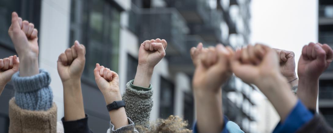 Menschen halte ihre Fäuste in die Luft. 