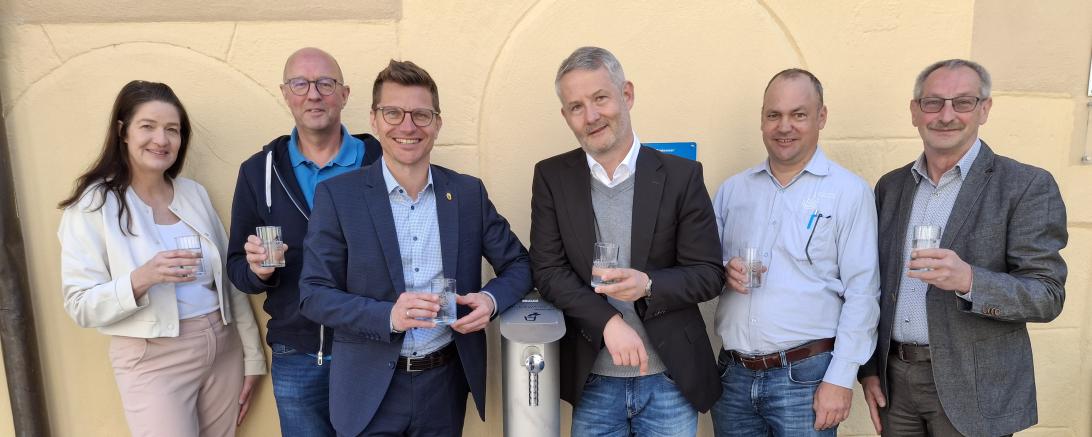 Probierten das erste Wasser aus dem neuen Trinkbrunnen vor der Tourist-Information: (v. l. n. r.): Martina Schwarzer (Werkleiterin Stadtwerke), Peter Ringle (BEULCO GmbH & Co. KG), Oberbürgermeister David Wittner, Andreas Wagnleitner (Geschäftsführer Eisen-Fischer GmbH), Frank Schmidtkunz (Wassermeister Stadtwerke) und Martin Bickelein (Technischer Werkleiter Stadtwerke). Der Trinkwasserbrunnen steht der Öffentlichkeit ab sofort zur kostenfreien Nutzung zur Verfügung.
