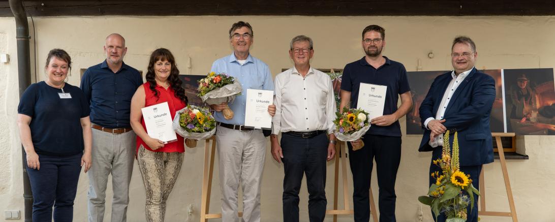 Auf der Bühne bei der Verleihung des Fotopreises des Bezirks Schwaben (v. l. n. r.): Museumsleiterin Conny Zeitler, Bezirksheimatpfleger Christoph Lang, die Zweitplatzierte Claudia Specht, der Erstplatzierte Peter Hildebrand, stellvertretender Bezirkstagspräsident Peter Schiele, der Drittplatzierte Gregor Hanewacker und Edgar Rölz (Kulturbeauftragter Bezirk Schwaben, Bezirksrat).