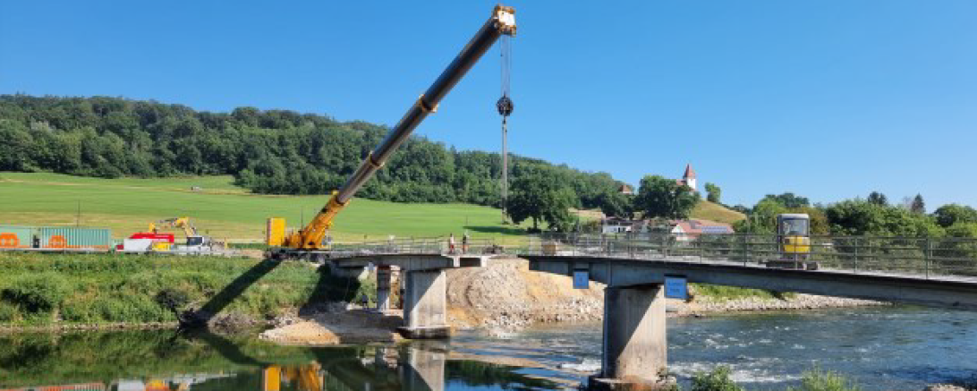 Das Foto zeigt die Bauarbeiten an der alten Donaubrücke in Schäfstall mit dem Rückbau der Überbauplatte. Das mittlere Segment ist bereits teilweise ausgehoben.  