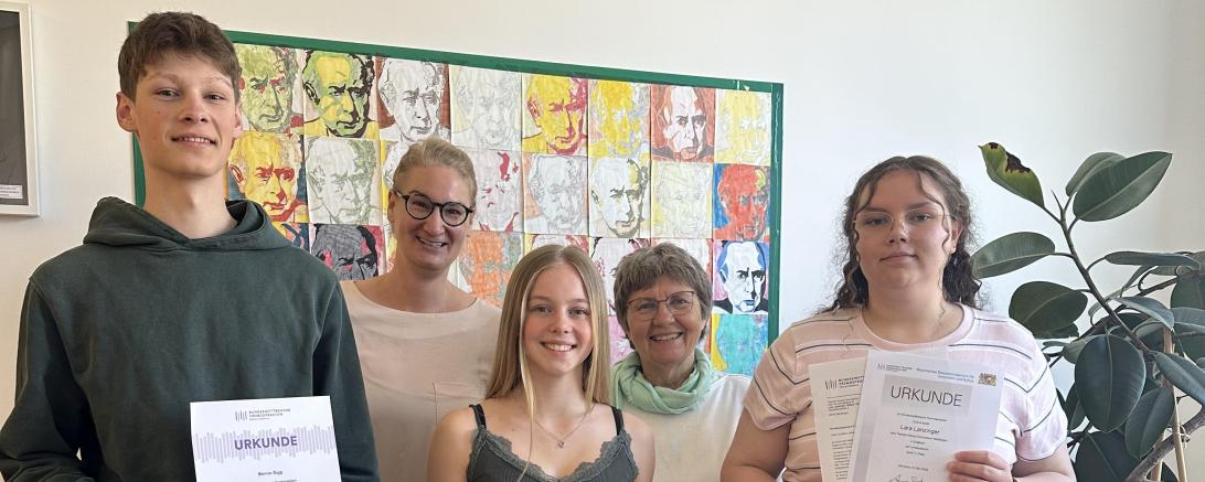 Wettbewerbsbeauftragte Silke Knoll und Schulleiterin Dr. Renate Rachidi (hinten) überreichten Benno Sigg, Emma Dotzauer und Lara Lanzinger (vorne v.l.n.r.) die Urkunden für die erfolgreiche Teilnahme am Bundeswettbewerb Fremdsprachen.