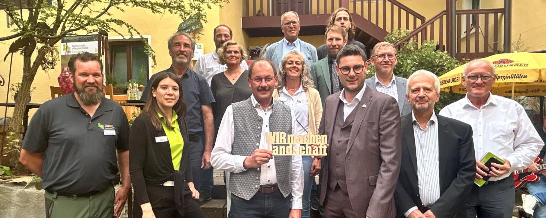 Mit einem Festakt auf dem Holunderhof Lohe wurde am 21. Juli das 10-jährige Bestehen des Landschaftspflegeverbandes gewürdigt. Auf dem Bild unter anderem zu sehen Geschäftsführerin Annika Sezi (2.v.l.), Kreisobmann Karlheinz Götz (mitte links), Bürgermeister Oettingen Thomas Heydecker (hintere Reihe mitte), Landrat Michael Dinkelmeier (mitte rechts), Landrat a.D. Stefan Rößle (3.v.r.) und Wolfram Güthler (2.v.r.) vom Bayerischen Staatsministerium für Umwelt und Verbraucherschutz. 