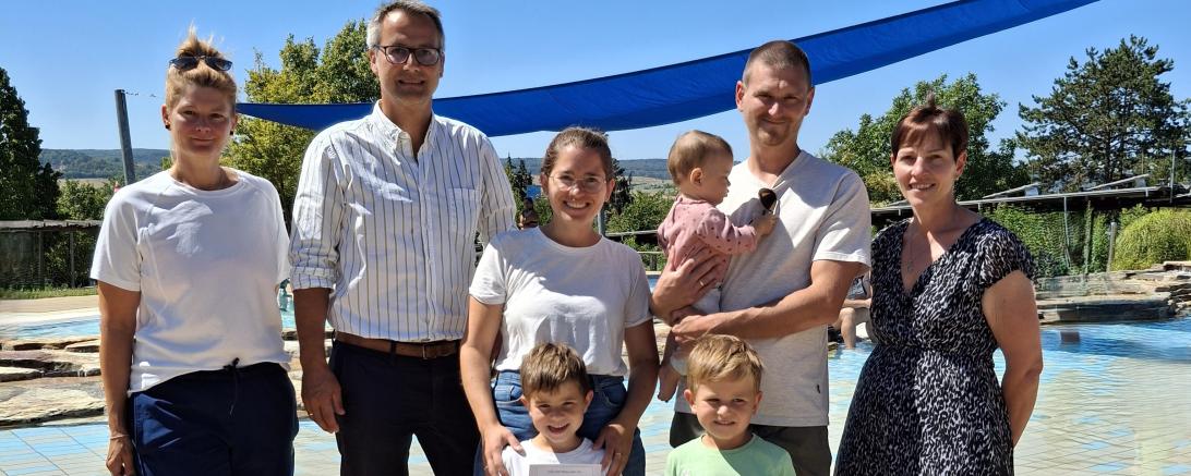 Ein besonderer Freibadbesuch für Familie Hillenmeyer: Als 100.000. Besucher der Saison erhielten Nina und Max Hillenmeyer sowie ihre Kinder Lorenz, Emil und Ida eine Saisonkarte für die ganze Familie und ein Badetuch. Die Glückwünsche überbrachten Nicole Hofmann (links), 2. Bürgermeister Steffen Höhn (2. v. l.) und Simone Leidel (rechts). 