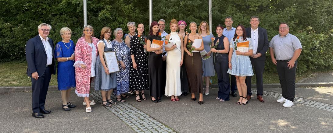 Nach der Übergabe der Gesellenbriefe tragen sich die frischgebackenen Gesellinnen mit den Ehrengästen zum Gruppenbild.