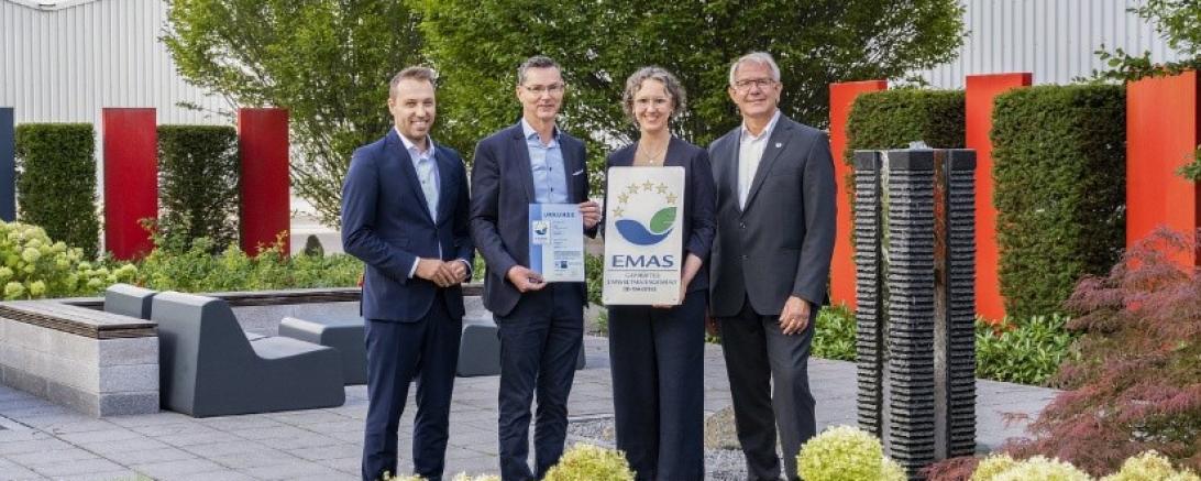 Übergabe der EMAS-Urkunde durch Matthias Hausmann (IHK Schwaben, links) im Beisein von Martin Stegmair (stellv. Landrat, rechts) an Roland Handschiegel und Stine Blinne von Hama.