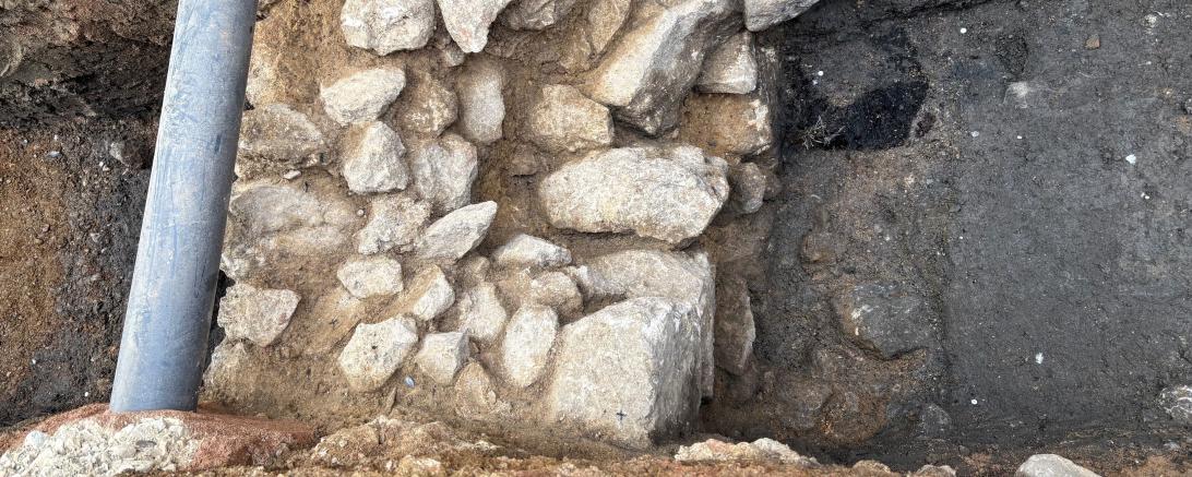 Die gefundene Mauer samt dem Rest des Holzpflocks (dunkle Stelle rechts oben neben der Mauer)