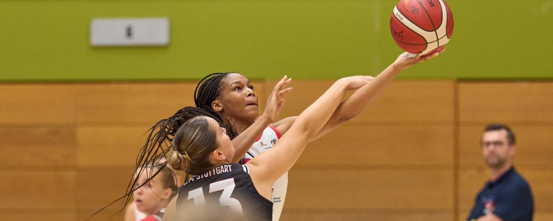 Wirklich kein Foul-Pfiff? Makiyah Williams wird beim Korbwurf gestört, trifft aber trotzdem. Die US-Amerikanerin war Topscorerin beim Match gegen Stuttgart. Headcoach Rozitis beobachtet die Szene im Hintergrund.