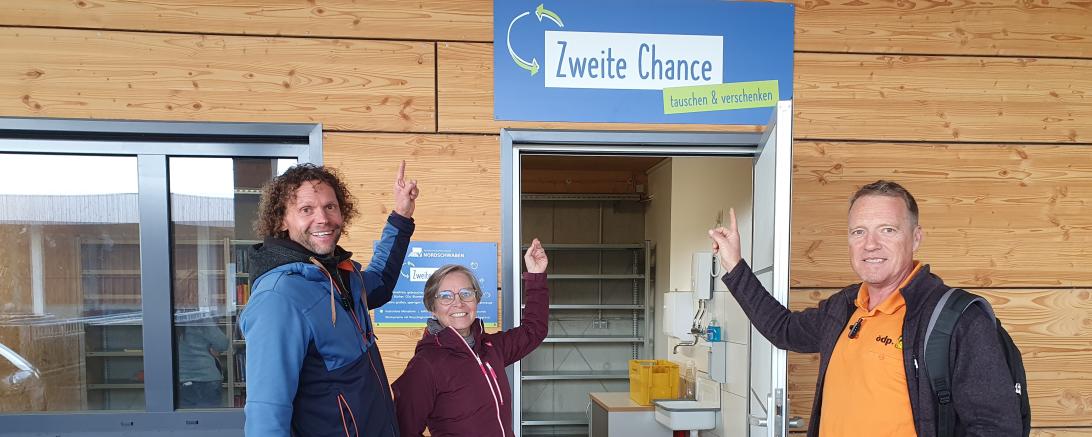 Michael Ölhorn, Andrea Kugler und Kreisrat Matthias Fritzsche von der ÖDP verweisen auf die „Zweite Chance“ im Recyclinghof Nördlingen. Ein eigener Raum lädt Bürgerinnen und Bürger ein, brauchbare Dinge einer weiteren Nutzung zur Verfügung zu stellen.