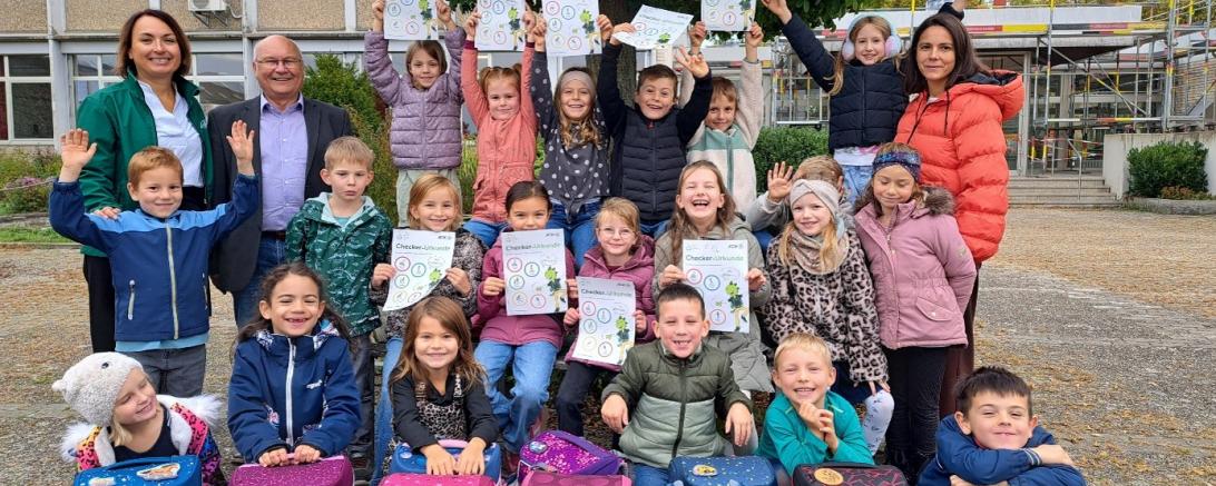 Kinder und Lehrkraft der Grundschule Deiningen freuen sich mit (stehen v. links). AOK-Direktorin Michaela Kluger und AOK-Beirat Bruno Schönherr.
