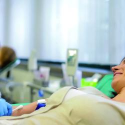 Frau auf Liege wird Blut abgenommen
