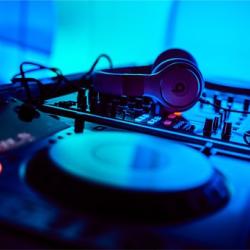 Das Bild zeigt die Schallplatten und Kopfhörer eines DJs