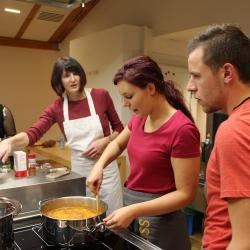 Das Bild zeigt Menschen, die miteinander kochen.