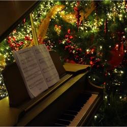 Das Bild zeigt ein Klavier mit einem Weihnachtsbaum