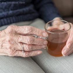 Das Bild zeigt eine Oma beim Teetrinken.