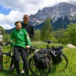 Das Bild zeigt zwei Radfahrer in den Alpen.