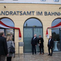 Hermann Faul, Stefan Rößle, Ulrich Lange und Stadträte enthüllen Schriftzug Landratsamt im Bahnhof